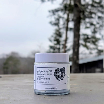 Jar of lotion on a wooden surface with trees in the background